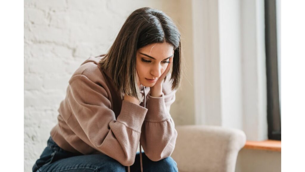頬杖をついて暗い表情をしている女性の写真