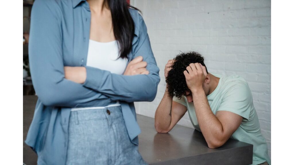 腕組みをしている女性と頭を抱えている男性の写真