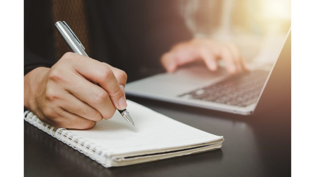 パソコンを開きメモをとっている写真
