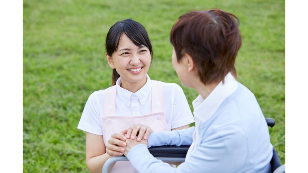 介護職員と利用者が手を取り見つめ合っている写真