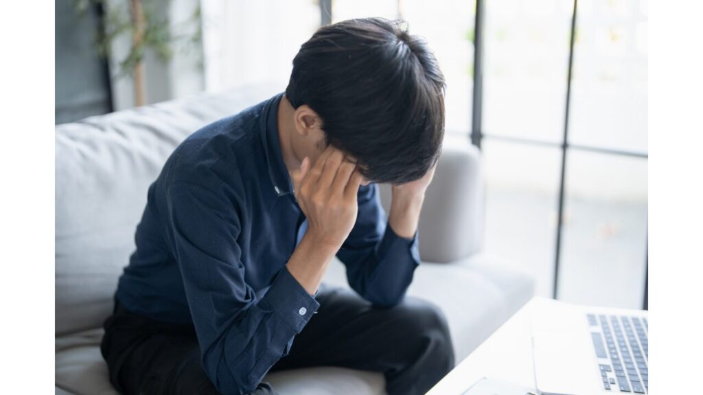 頭を抱える男性の写真